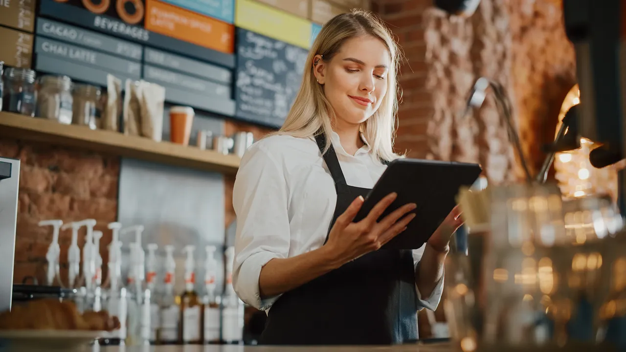 woman operating a mobile POS at a restaurant counter