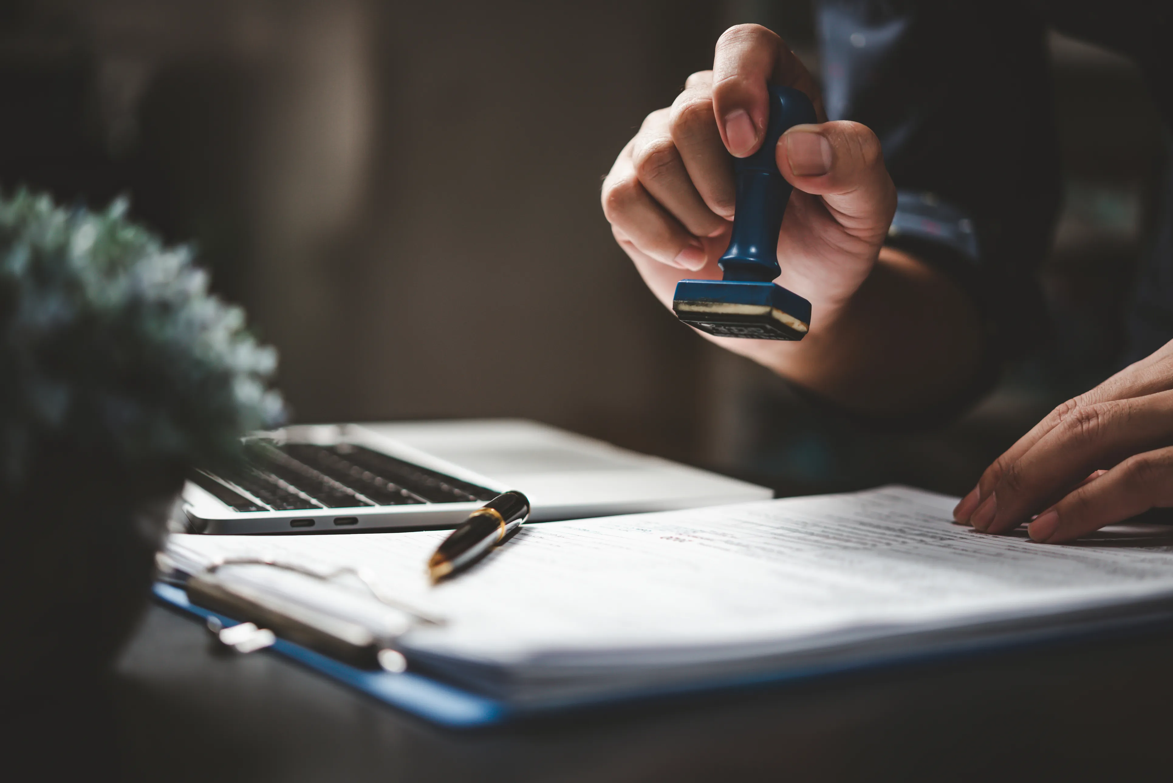 Hands of a person stamping a document in a office setting