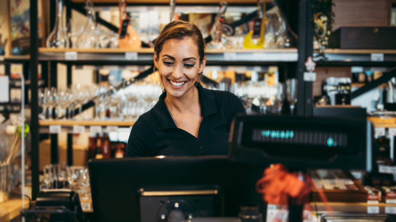 A woman operating the cash register at a restaurant or bar