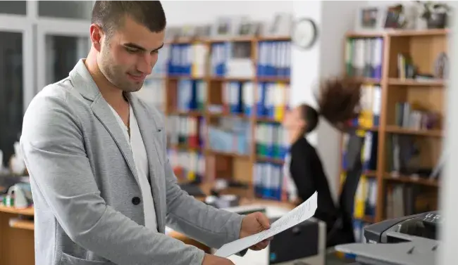 young man archiving documents in an office