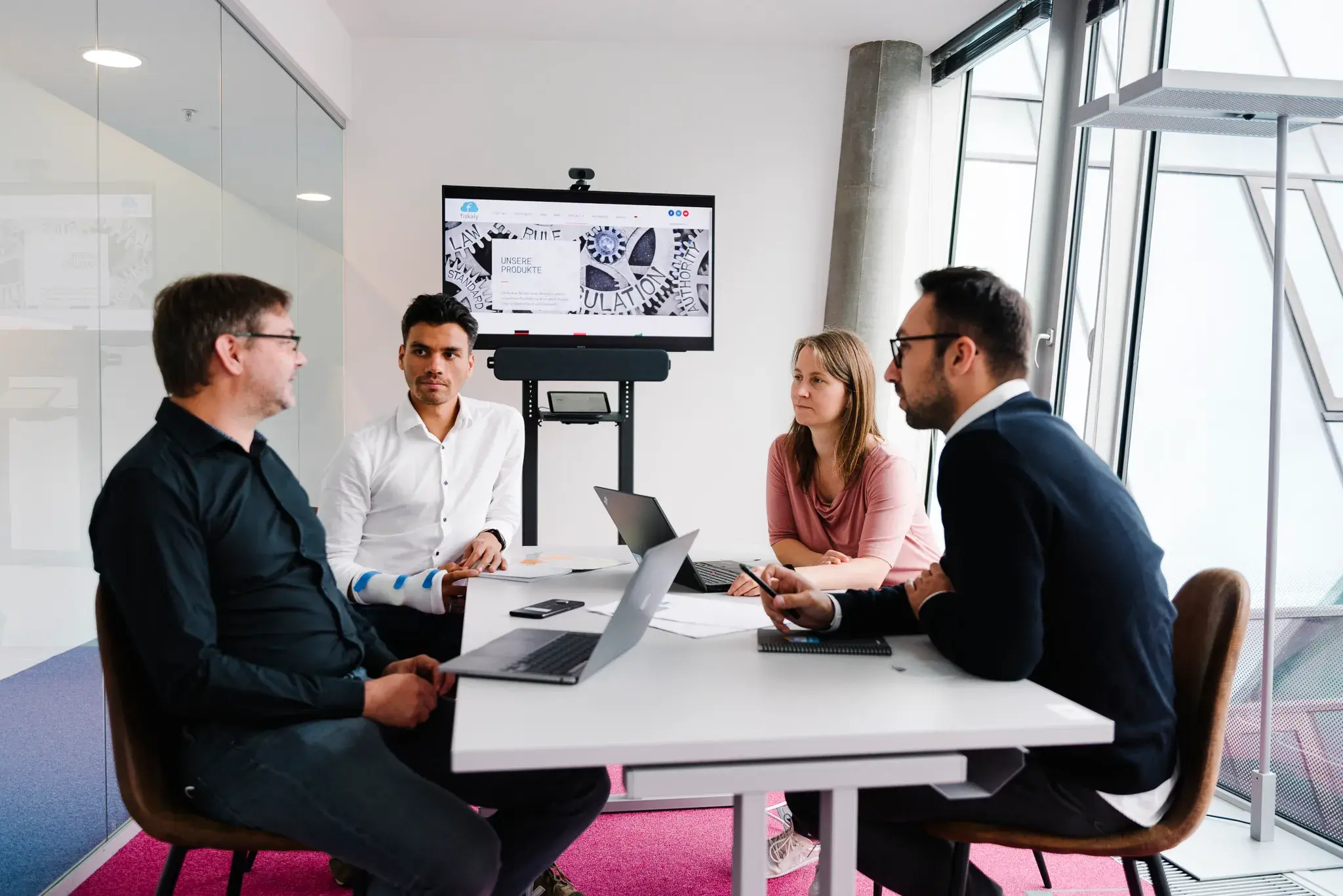 Simon Tragatschnig, Oliver Abl, Gerlinde Kaineder, Roland Wiesinger sit at the table in fiskaly Vienna office and talk