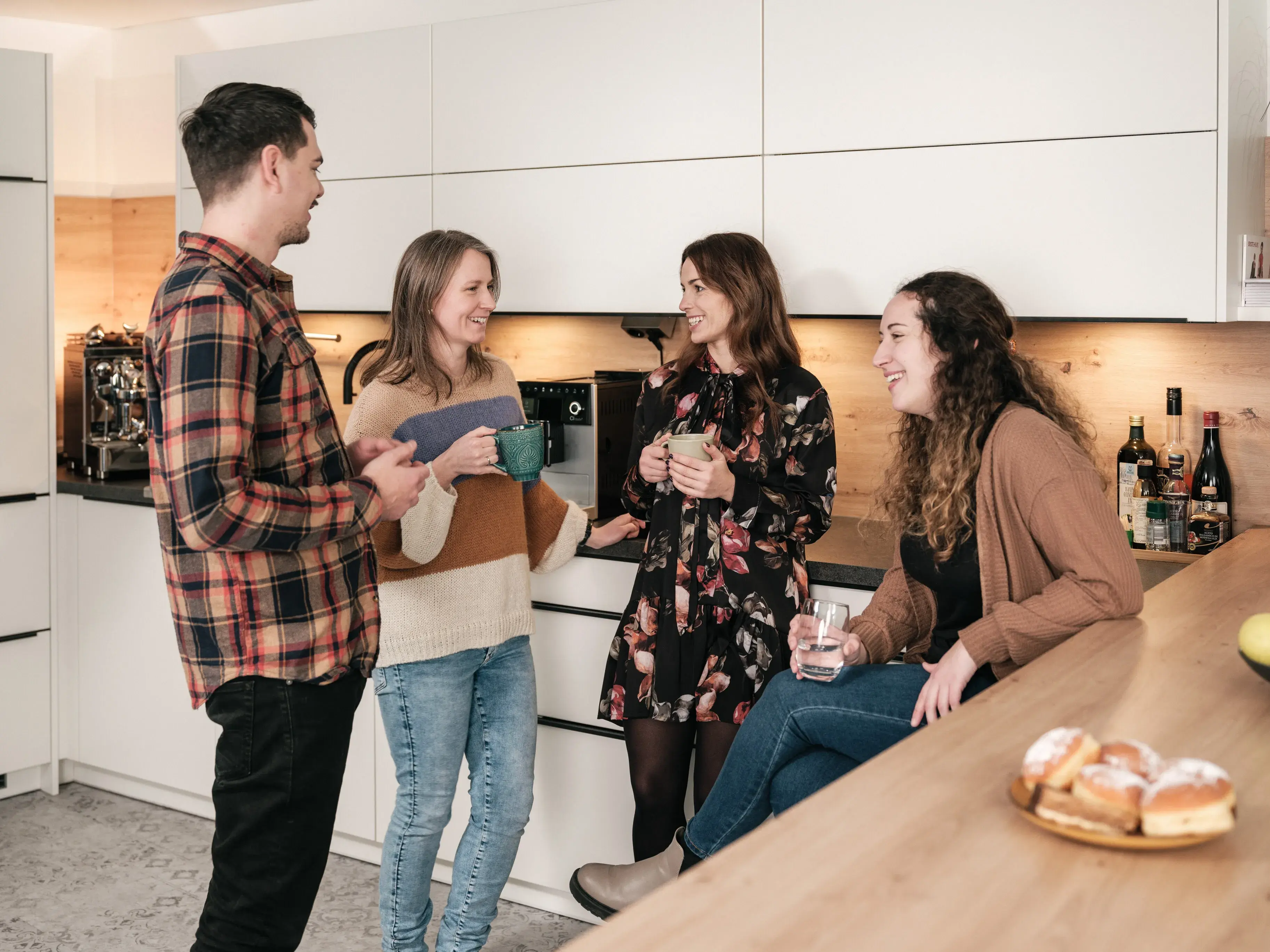fiskaly employees chat nicely in the kitchen in Vienna office with coffee mugs about fiskaly culture, fiscalization and electronic receipts