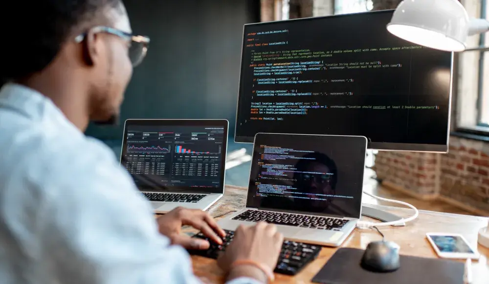 Un uomo davanti a dei computer portatili e a uno schermo sui cui viene mostrato il software API VeriFactu, conforme alla legge antifrode in Spagna tramite SIGN ES di fiskaly