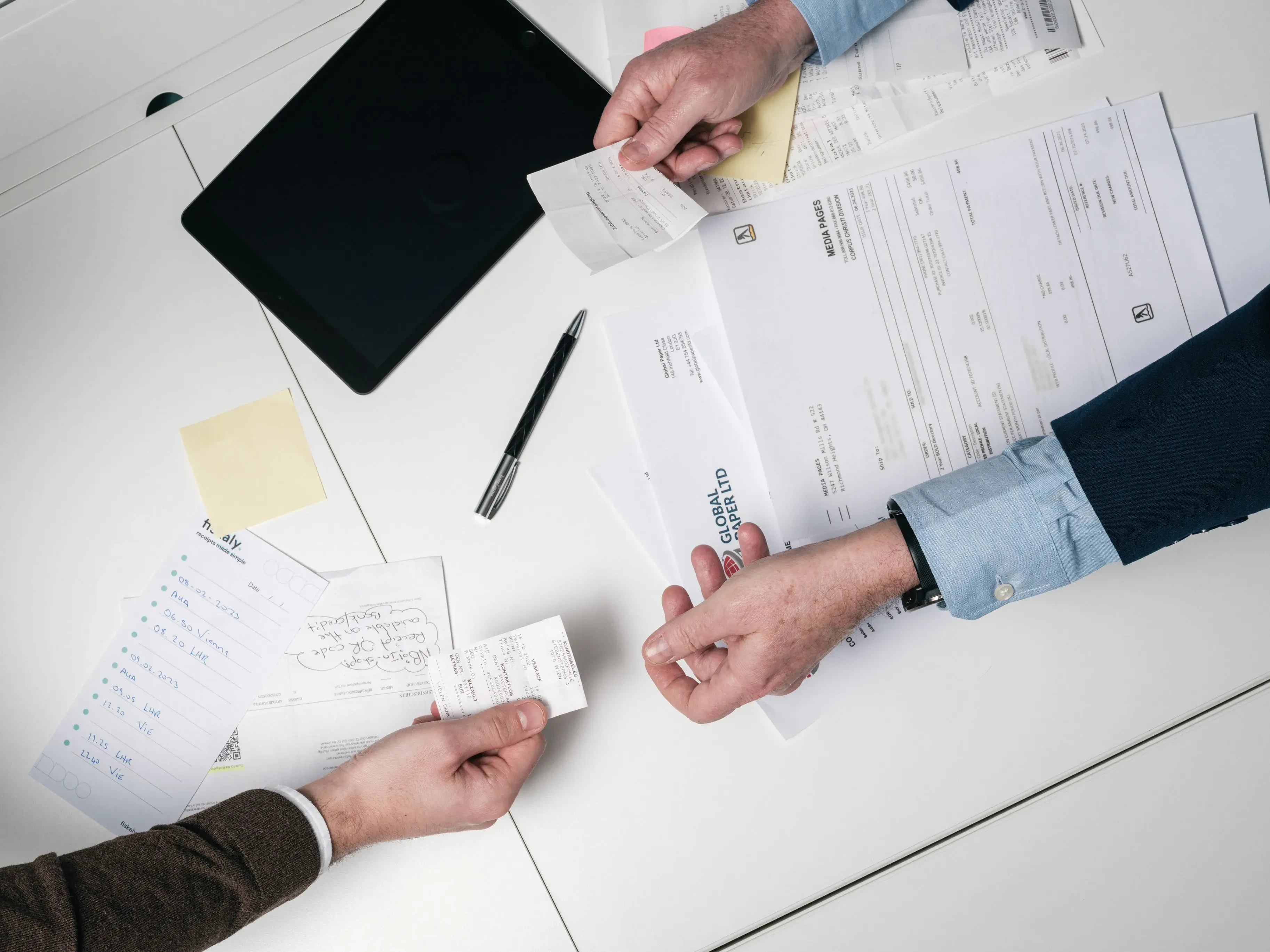 People's hands, passing receipts and notes to each other