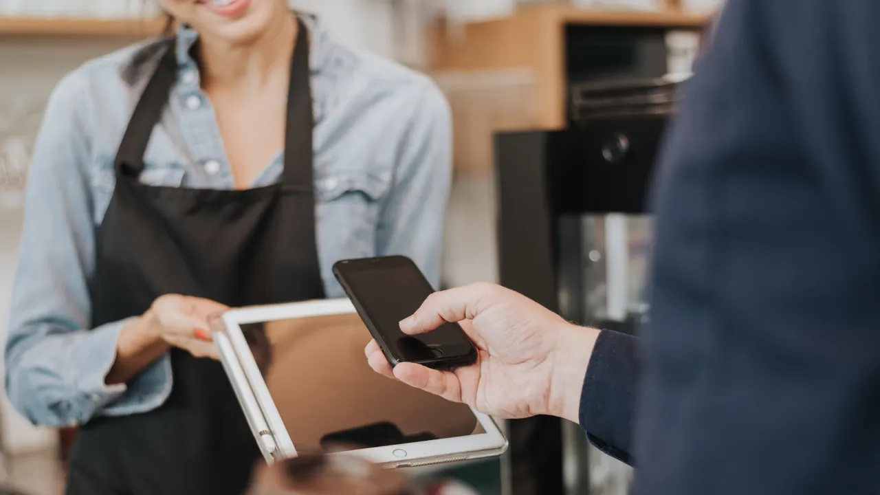 customer at the checkout scanning a screen with their phone