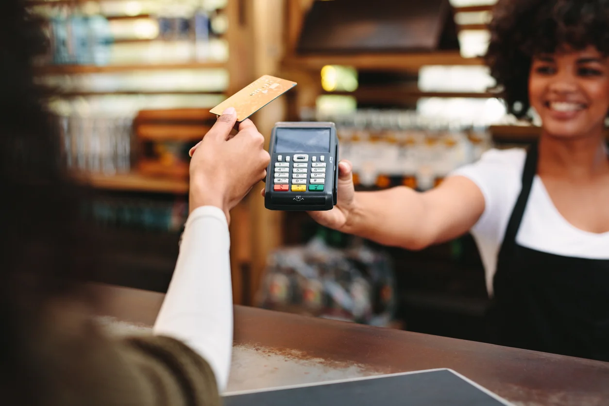 Smiling woman at the cash register with a paying customer