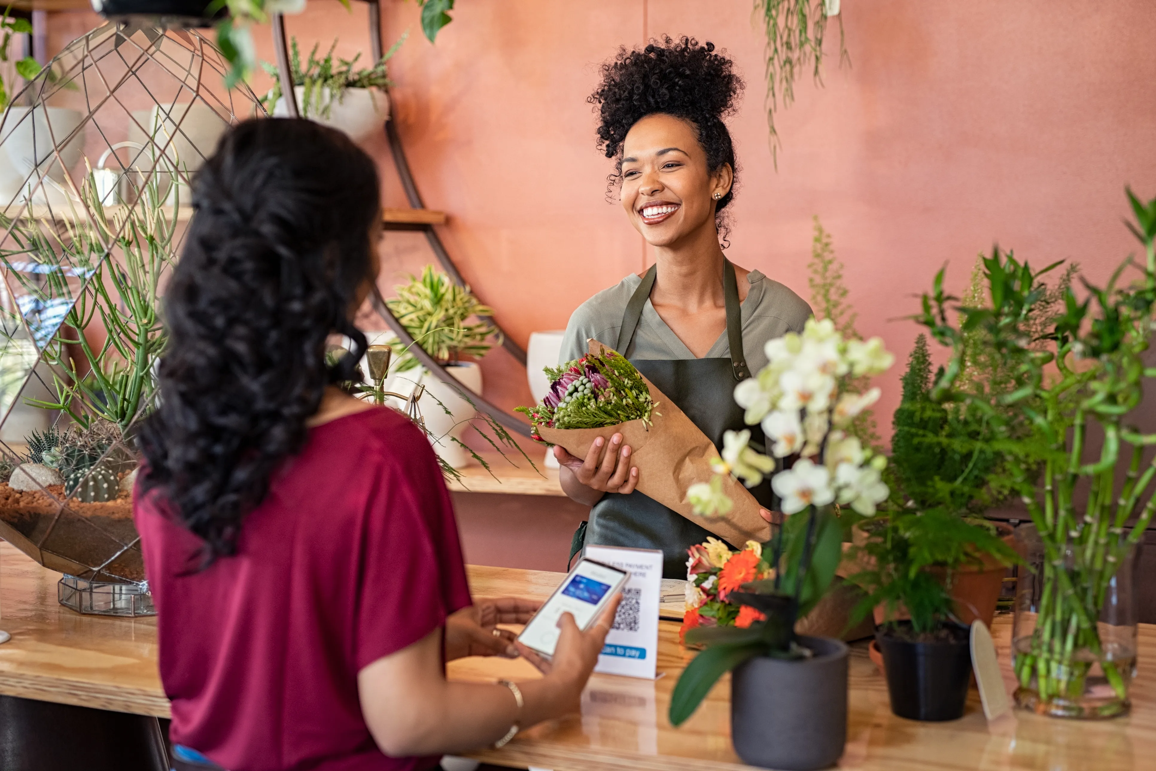 Neighborhood florist and customer at checkout during payment