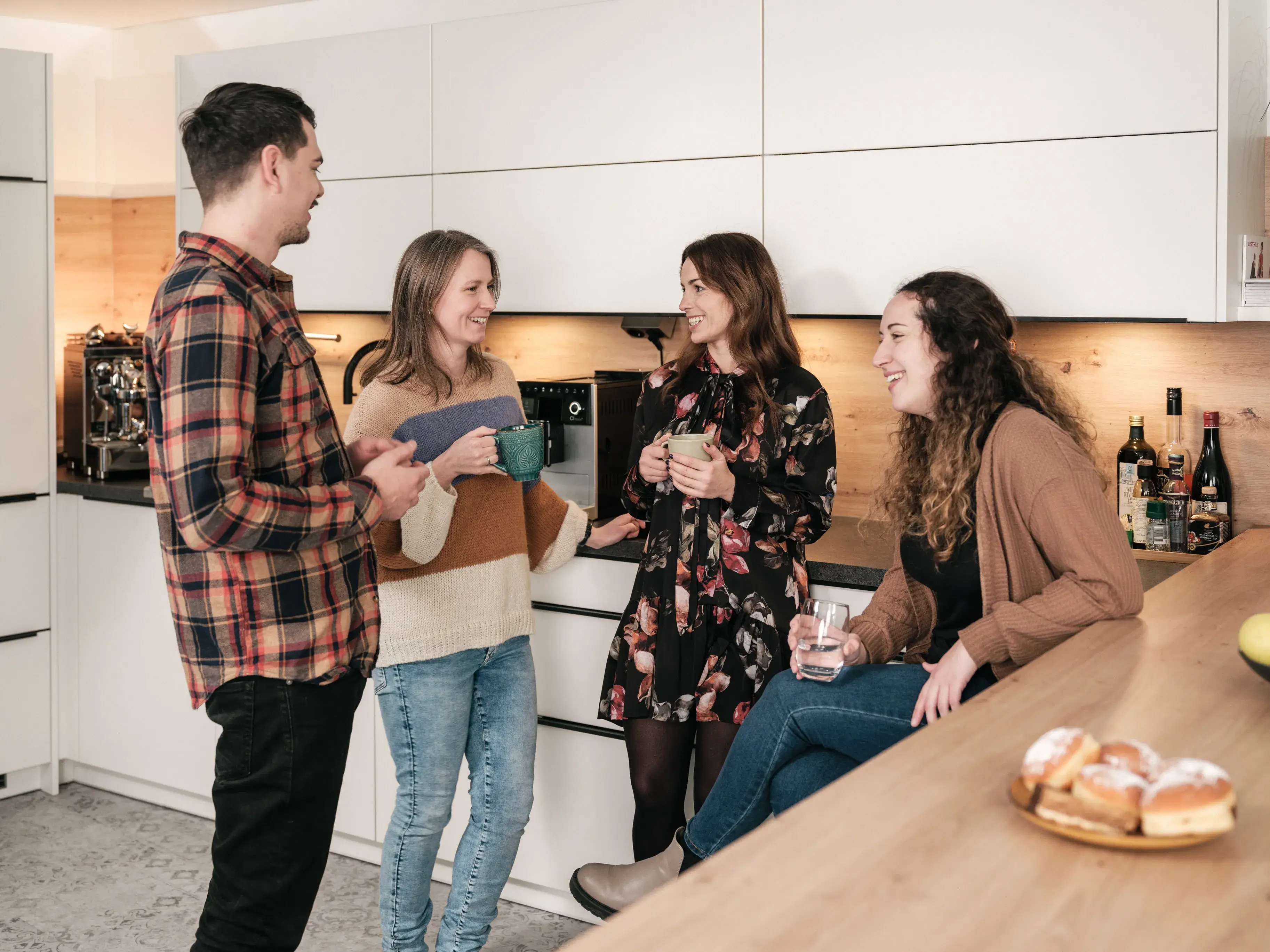 fiskaly-Mitarbeiter chatten in der Küche im Wiener Büro mit Kaffeetassen über die fiskaly-Kultur, Fiskalisierung und elektronische Belege